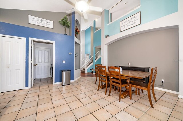 tiled dining space featuring high vaulted ceiling and ceiling fan