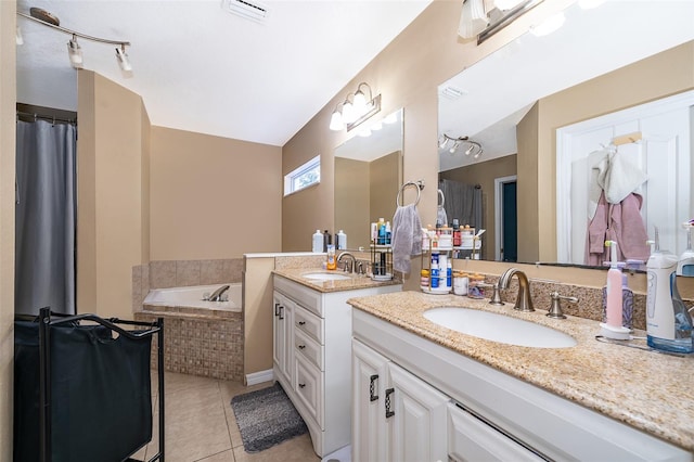 bathroom featuring vanity, tiled bath, and tile patterned flooring