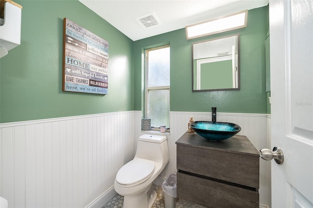 bathroom with toilet, vanity, and tile patterned floors