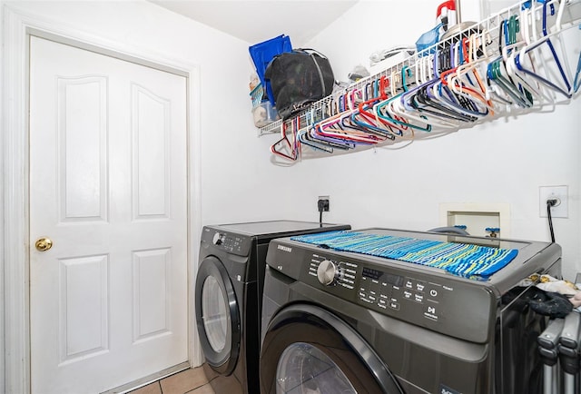 laundry area featuring washing machine and clothes dryer and light tile patterned floors