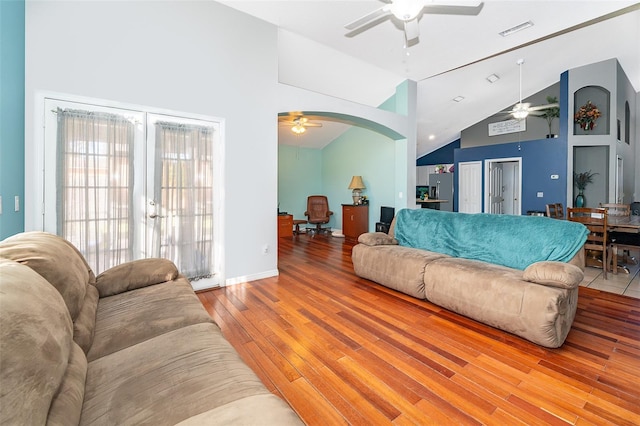 living room featuring high vaulted ceiling, french doors, and light hardwood / wood-style flooring