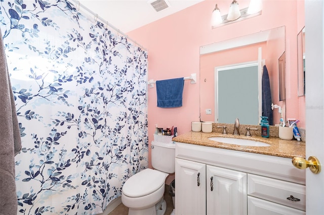 bathroom with toilet, vanity, and a shower with shower curtain