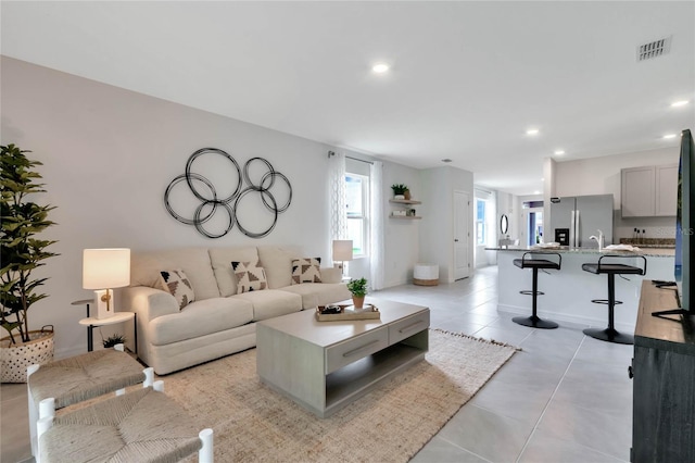 living room with light tile patterned floors and sink