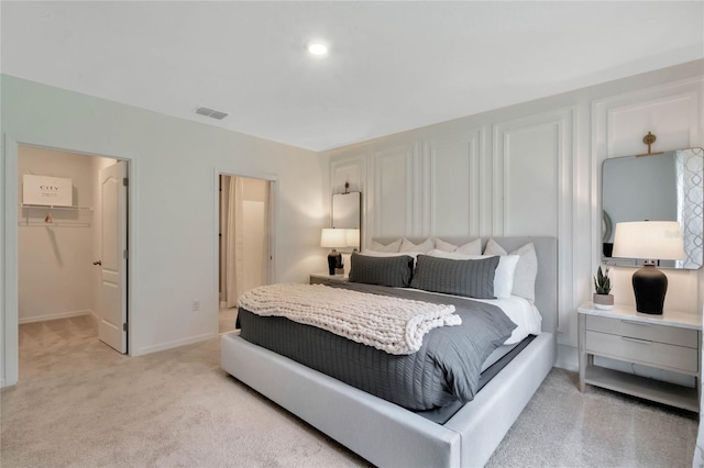 bedroom featuring light carpet, a closet, and a spacious closet