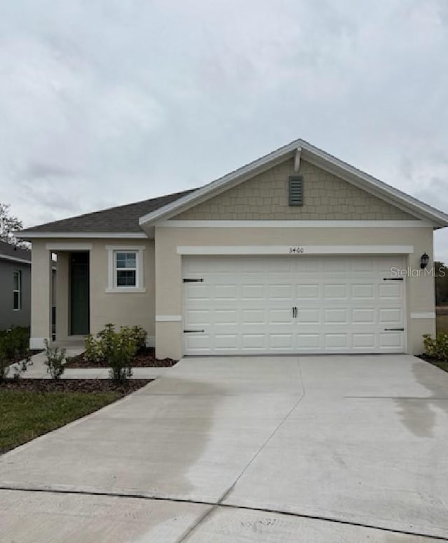 single story home with a garage, concrete driveway, and stucco siding