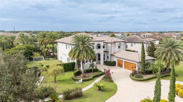 mediterranean / spanish-style home featuring a garage and a front lawn