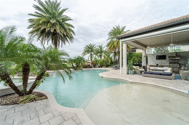 view of pool featuring a patio area, exterior kitchen, and grilling area