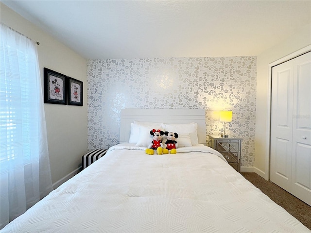 carpeted bedroom with multiple windows and a closet