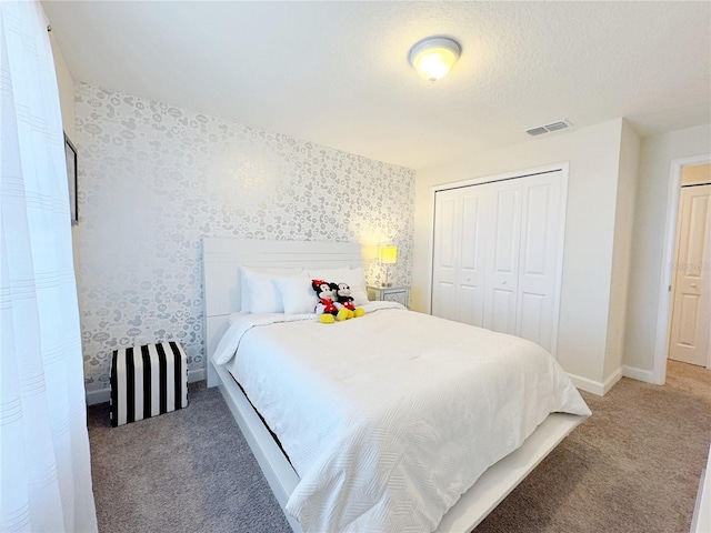 bedroom featuring a closet, carpet floors, and a textured ceiling