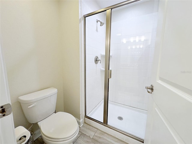 bathroom with toilet and a shower with door