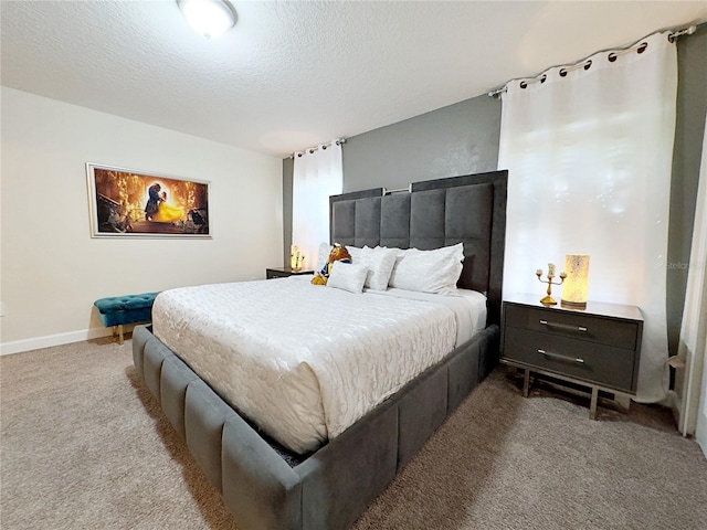 bedroom with a textured ceiling and light colored carpet