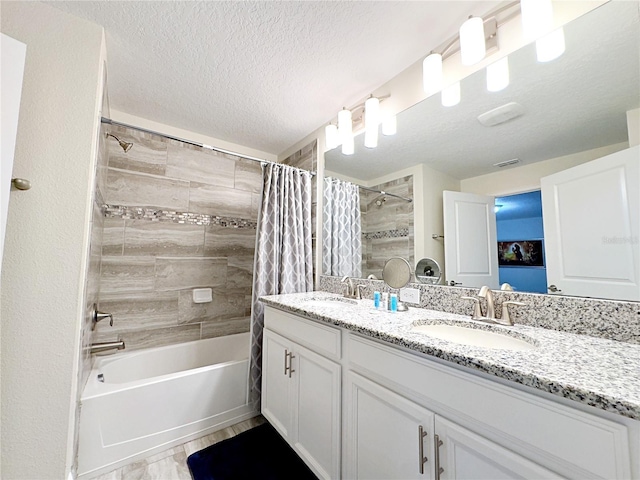 bathroom featuring vanity, a textured ceiling, and shower / tub combo with curtain