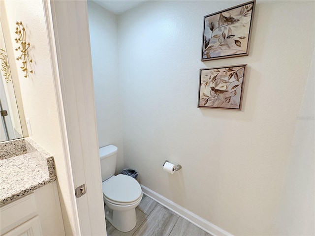 bathroom featuring vanity, toilet, and wood-type flooring