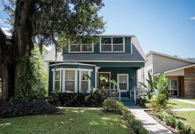 view of front of property featuring covered porch and a front lawn