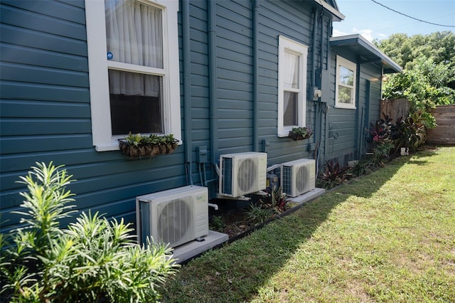 view of side of home featuring ac unit and a yard