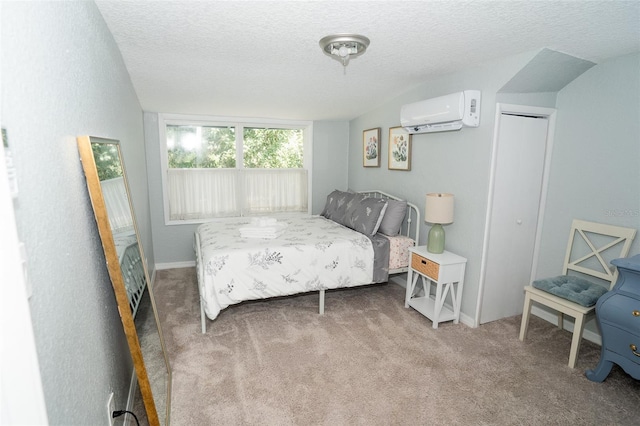 carpeted bedroom featuring a textured ceiling, a wall unit AC, and a closet