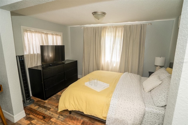 bedroom with dark hardwood / wood-style flooring and a textured ceiling