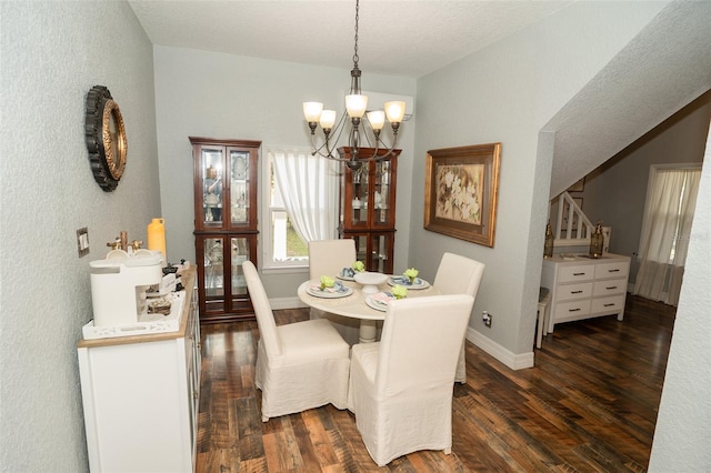 dining area with a chandelier, a textured ceiling, and dark wood-type flooring