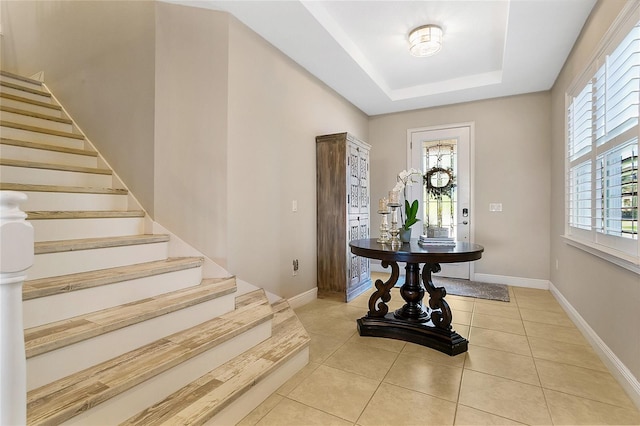 tiled entryway with a tray ceiling