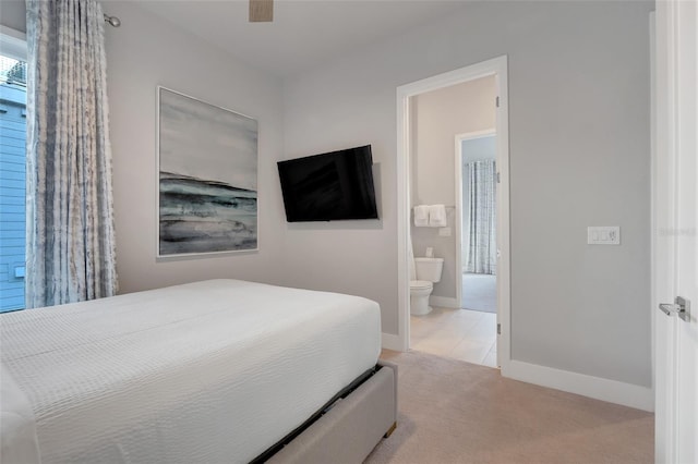 carpeted bedroom featuring ceiling fan and ensuite bath