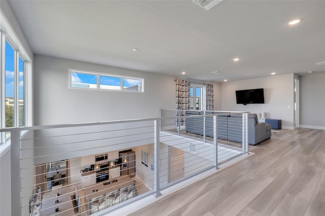 hall featuring light hardwood / wood-style floors and a healthy amount of sunlight