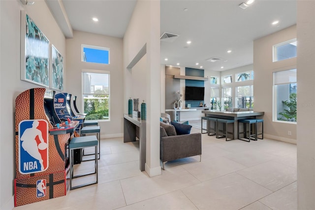 living room featuring light tile patterned floors and a towering ceiling