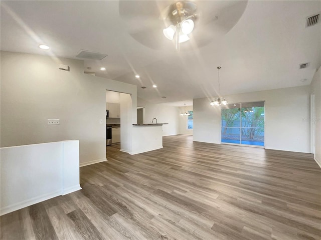 unfurnished living room with wood-type flooring and ceiling fan