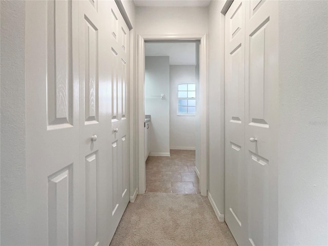 hallway featuring light colored carpet