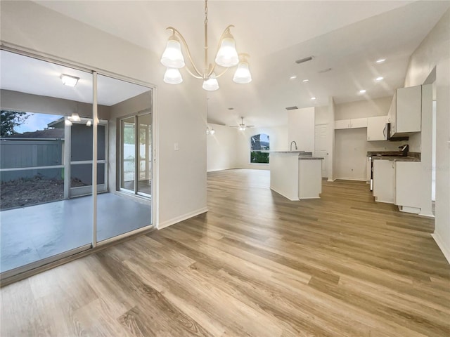 unfurnished dining area with plenty of natural light, sink, and light wood-type flooring