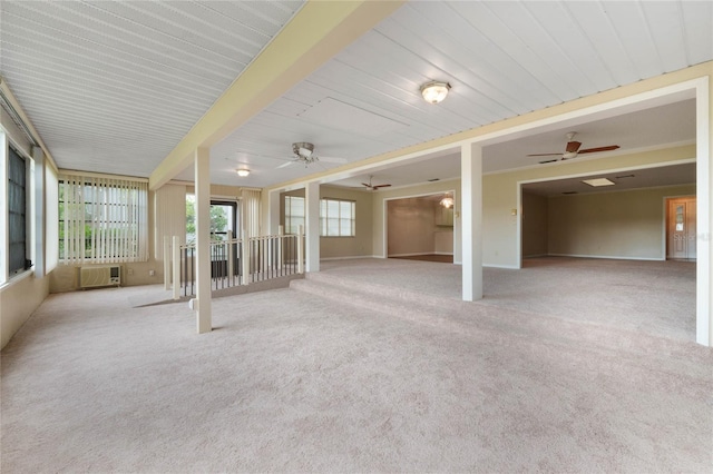 unfurnished sunroom featuring ceiling fan and a wall mounted air conditioner