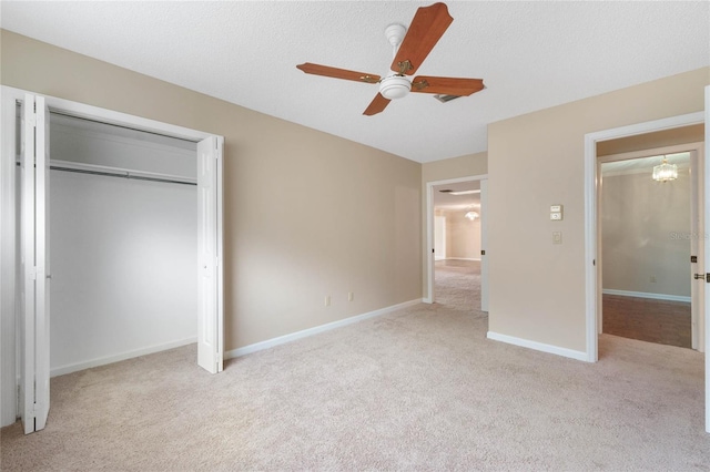 unfurnished bedroom featuring a textured ceiling, light carpet, ceiling fan, and a closet