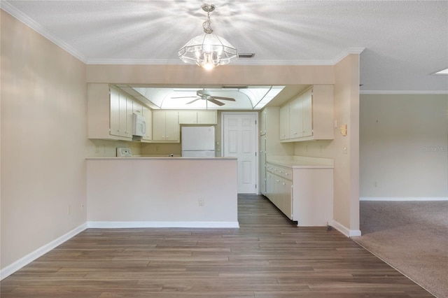 kitchen featuring wood-type flooring, white cabinetry, pendant lighting, white appliances, and ceiling fan with notable chandelier