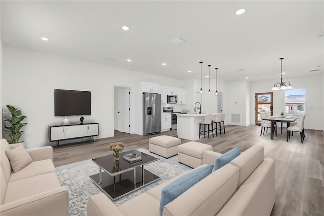 living room featuring light hardwood / wood-style floors and a chandelier