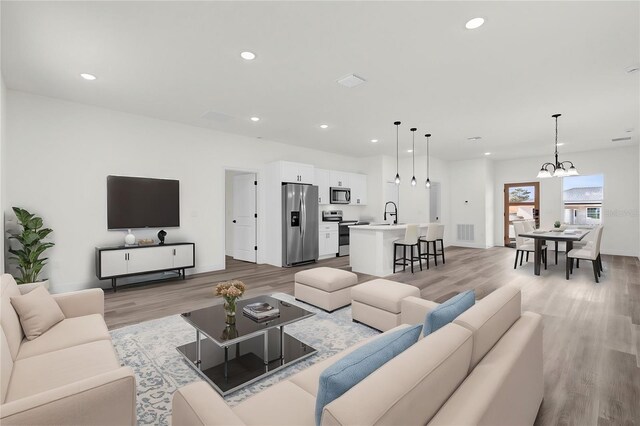 15123 SW 61st Court Rd, Ocala, FL 34473 - living room with light wood finished floors, a chandelier, recessed lighting, and baseboards