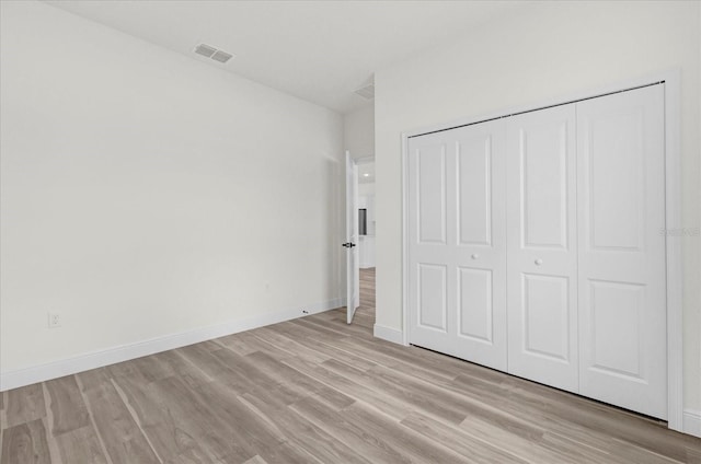 unfurnished bedroom featuring light wood-type flooring and a closet