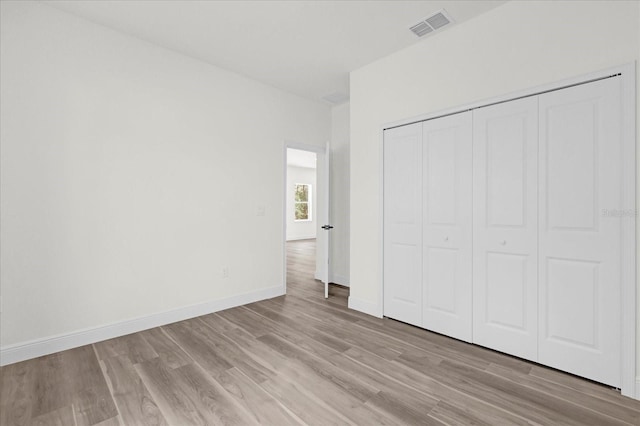 unfurnished bedroom featuring a closet and light hardwood / wood-style floors