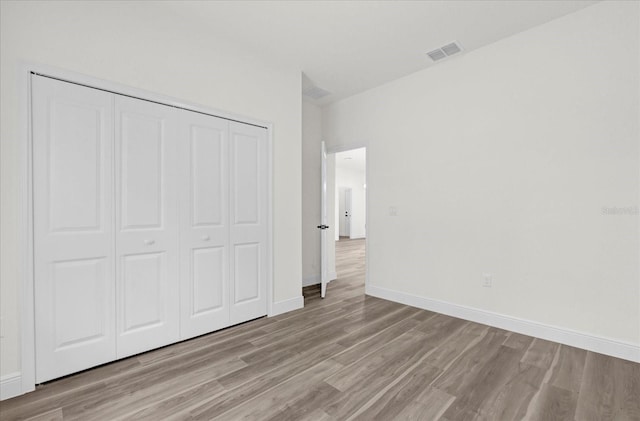 unfurnished bedroom featuring a closet and light wood-type flooring