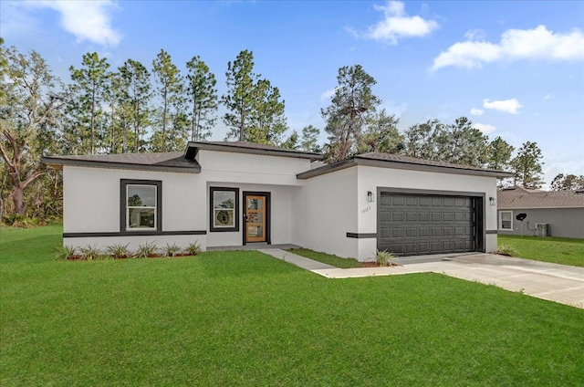 prairie-style house featuring an attached garage, concrete driveway, stucco siding, and a front yard