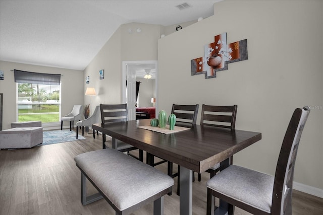 dining room featuring high vaulted ceiling and hardwood / wood-style flooring