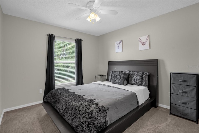 bedroom with ceiling fan, a textured ceiling, and carpet flooring