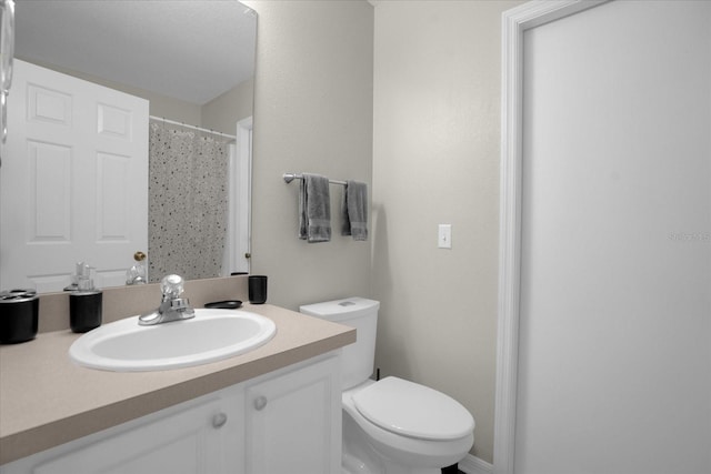 bathroom with curtained shower, vanity, and toilet