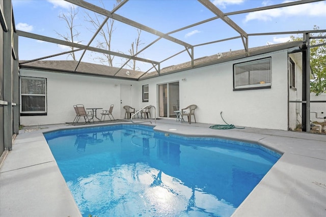 view of swimming pool featuring glass enclosure and a patio area