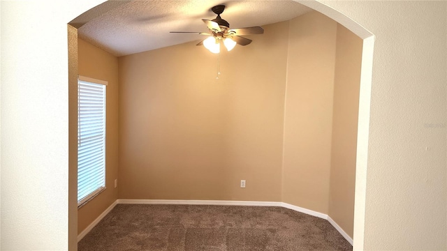 empty room with carpet flooring, a textured ceiling, ceiling fan, and a healthy amount of sunlight