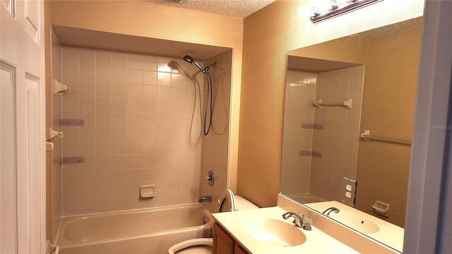 full bathroom featuring vanity, tiled shower / bath combo, a textured ceiling, and toilet