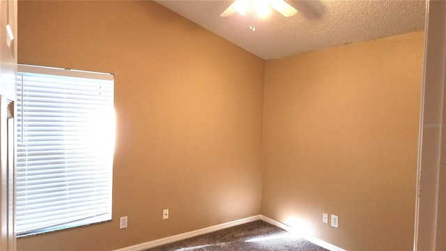 carpeted spare room with ceiling fan, a healthy amount of sunlight, and a textured ceiling