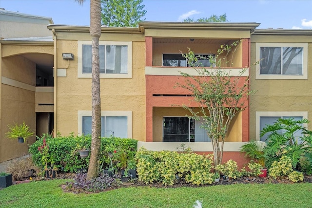 view of front of house with a front lawn and a balcony