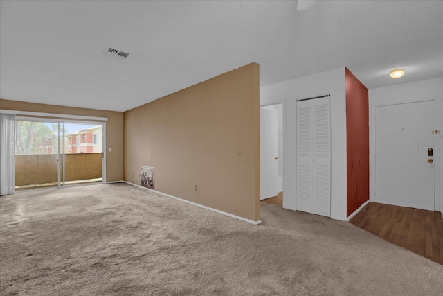 carpeted spare room featuring a textured ceiling