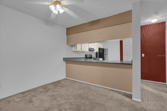 kitchen with sink, ceiling fan, a textured ceiling, light colored carpet, and black refrigerator