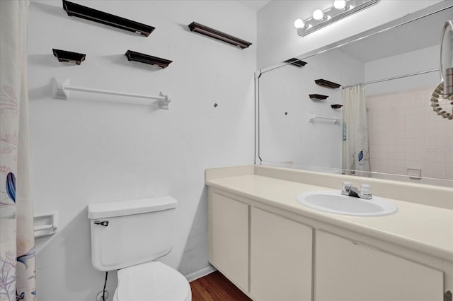 bathroom with walk in shower, hardwood / wood-style floors, vanity, and toilet