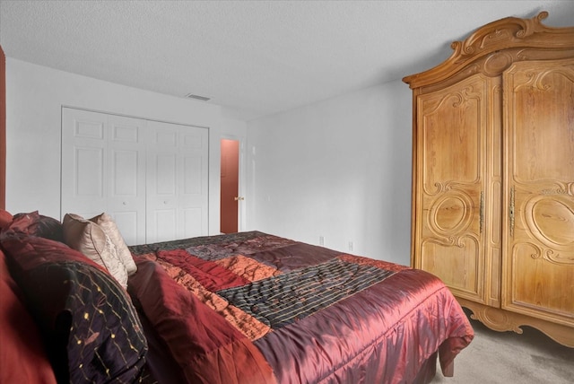 bedroom featuring a closet, a textured ceiling, and light colored carpet